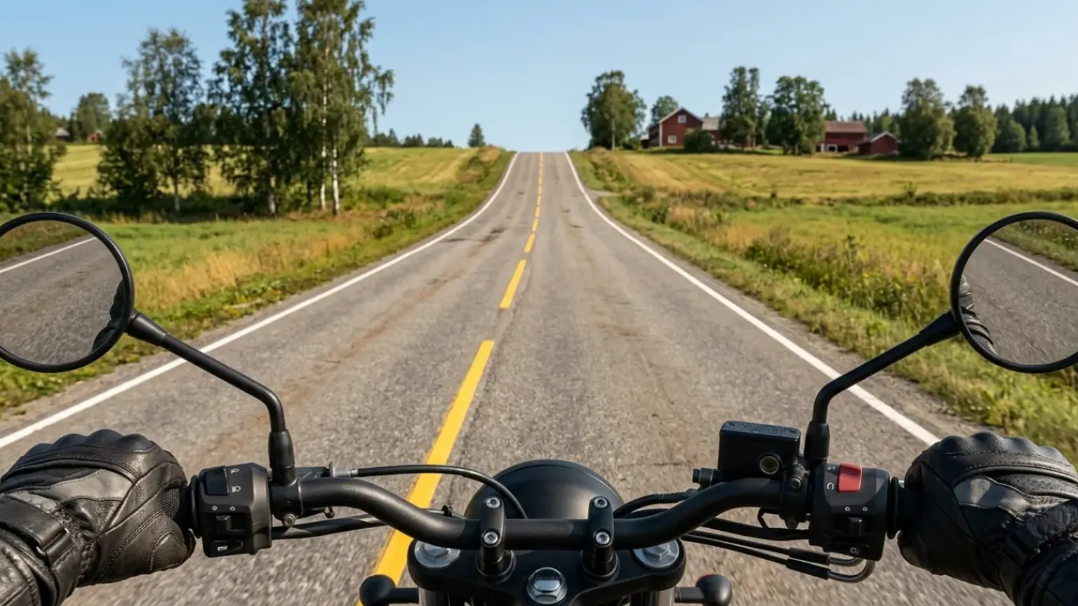 Sett fra styret på en motorsykkel: en rett landevei stiger mot en bakketopp der veien forsvinner, med gårder og jorder på begge sider.